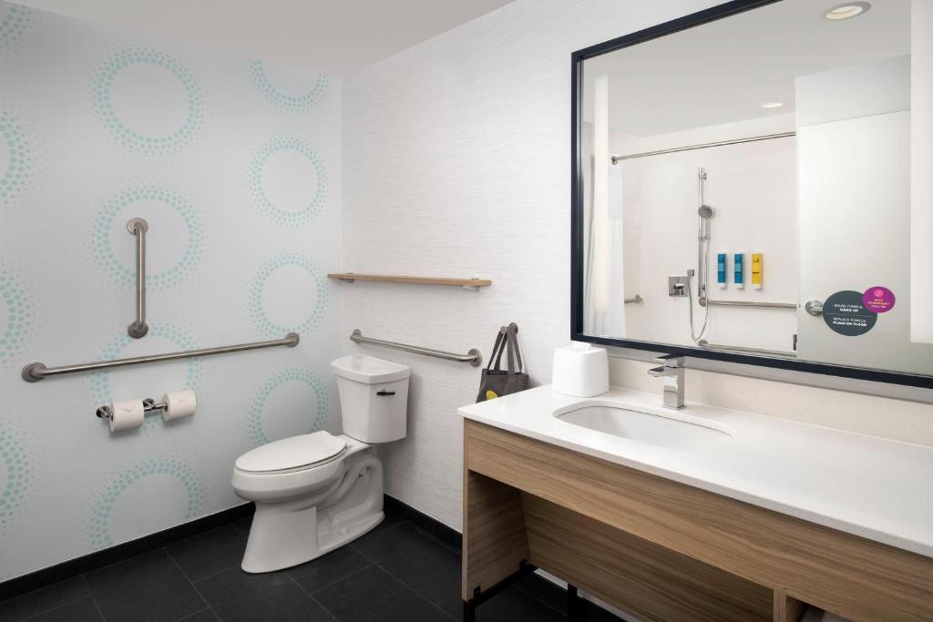 a bathroom with a toilet and a sink and a mirror at Tru By Hilton Mt Pleasant Charleston in Charleston