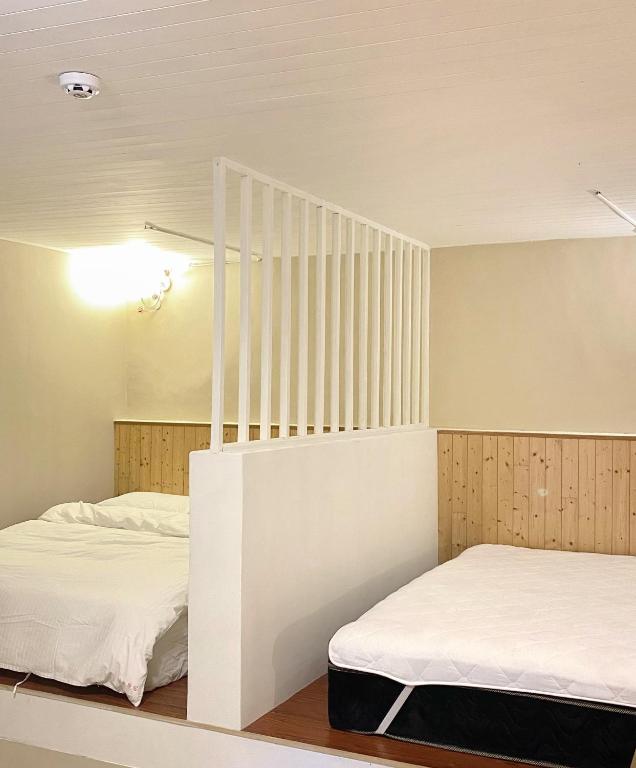 una camera con due letti e una scala di 寵物友善九份沐石原宿一館mu shi b&b a Ruifang