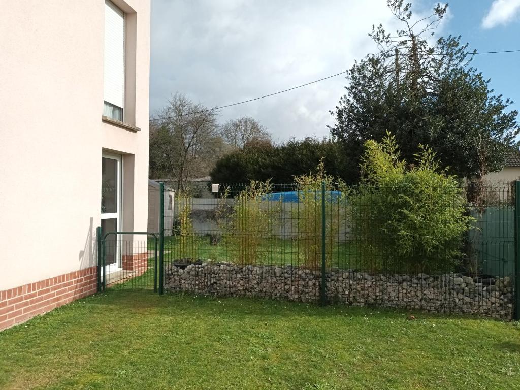 a fence in a yard next to a house at résidence la clairière aux portes de la baie de Somme in Abbeville