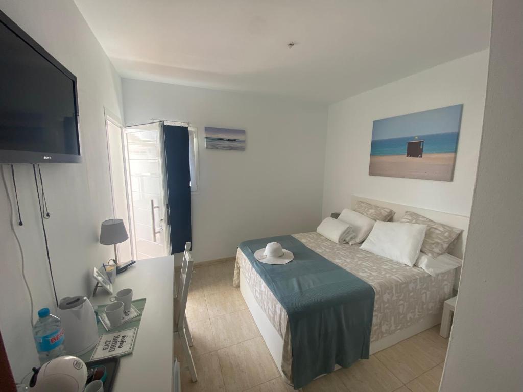 a small bedroom with a bed and a flat screen tv at MiVida in San Bartolomé