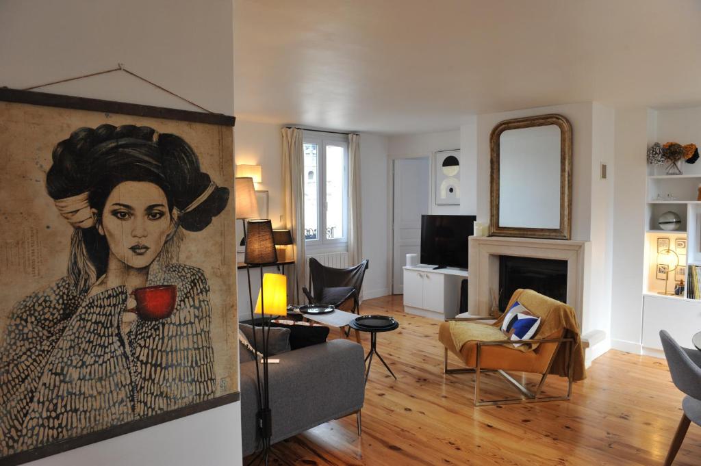 - un salon orné d'une peinture de femme dans l'établissement L'Appart Gîte de Charme, à Compiègne