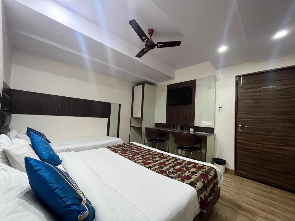 1 dormitorio con 1 cama y ventilador de techo en Hotel Rajshree en Agra