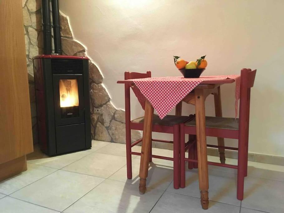 a table with a bowl of fruit on it next to a stove at Il Cottage di Stella incantevole appartamento in SantʼOreste
