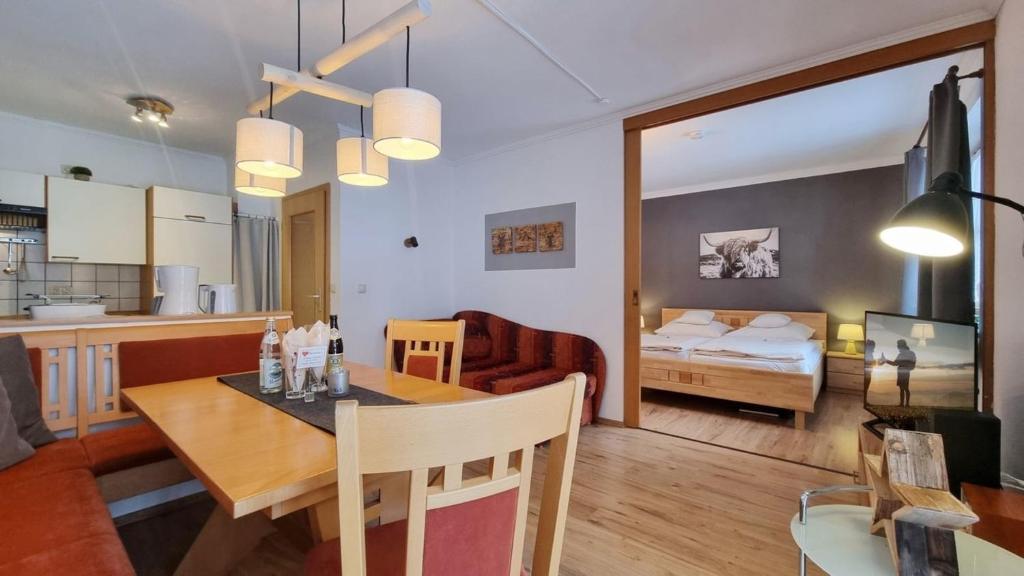 uma cozinha e uma sala de estar com uma mesa de jantar e um quarto em Hortensia -213- em Mittenwald