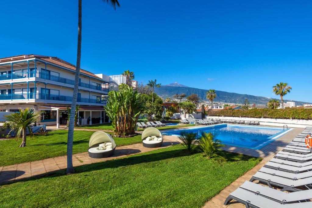 um resort com piscina e espreguiçadeiras em O7 Tenerife em Puerto de la Cruz