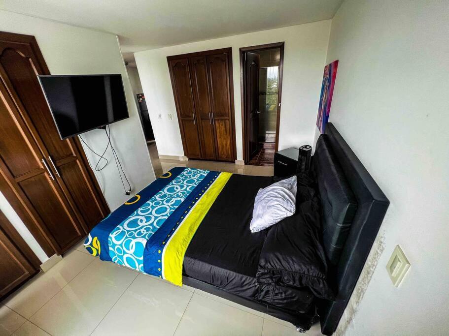 Schlafzimmer mit einem Bett und einem Flachbild-TV in der Unterkunft Hermoso apto en exclusiva zona de Pereira in Pereira