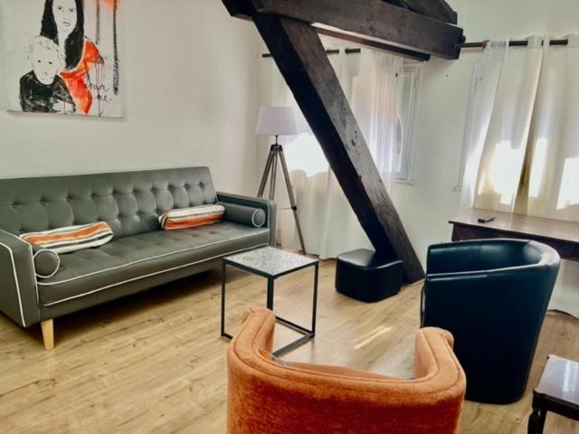 un salon avec un canapé et une chaise dans l'établissement Marvejol T2, à Toulouse