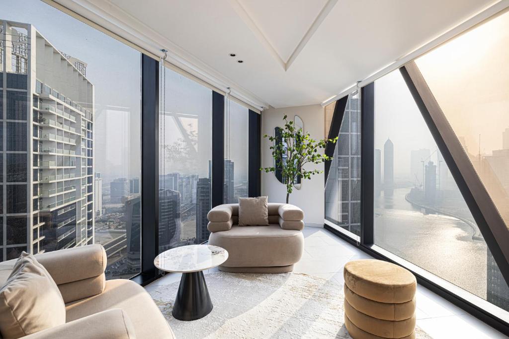 ein Wohnzimmer mit raumhohen Fenstern in der Unterkunft Magnificent 3BR Spectacular Canal & Burj View in Dubai