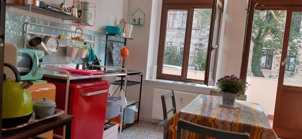 eine Küche mit einem Tisch und einem roten Kühlschrank in der Unterkunft Enjoy Goerlitz Augustastrasse in Görlitz