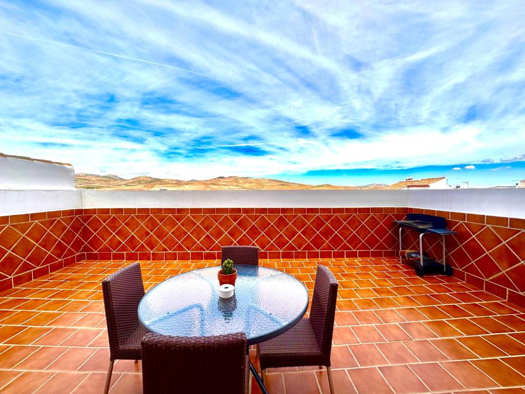einen Tisch und Stühle auf einer Terrasse mit Aussicht in der Unterkunft APARTAMENTO CAMINO DEL RIO in Ardales