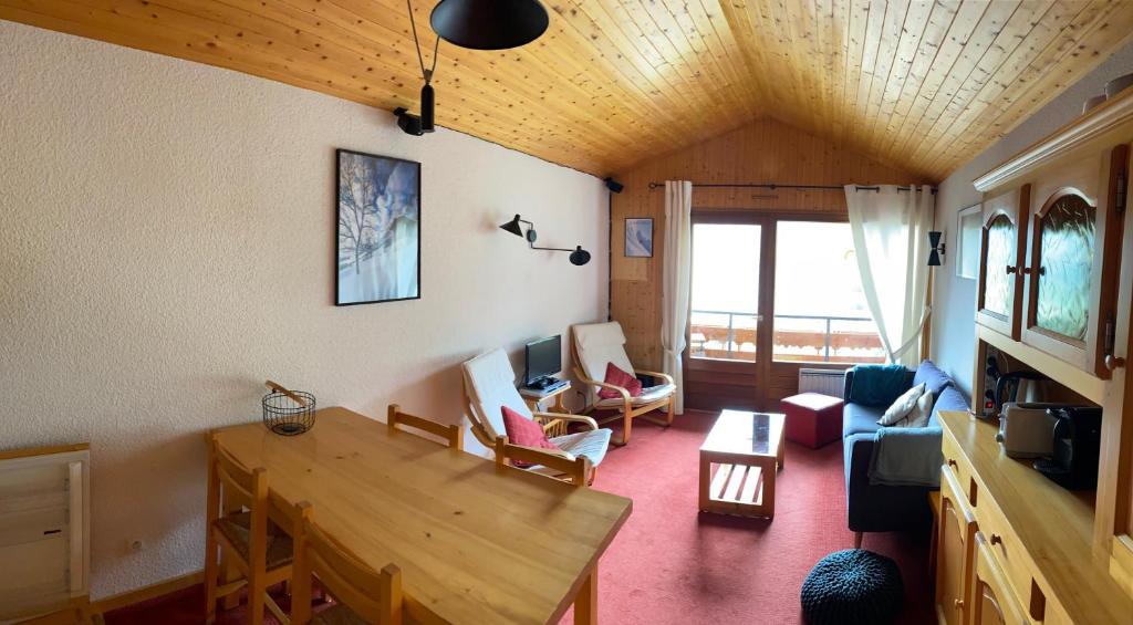 ein Wohnzimmer mit einem Tisch und Stühlen in der Unterkunft Charmant appart style chalet, simple et soigné in Le Grand-Bornand