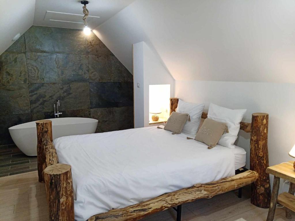 a bedroom with a large bed and a bath tub at Gîtes de l'Orée du Bois in Boussières