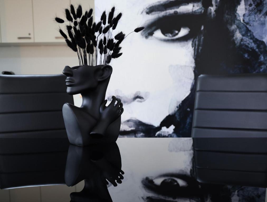Eine Statue einer Frau, die vor einem Gemälde steht. in der Unterkunft Vienna's Modern Black Beauty - Couples & Family-Friendly apartment in Wien