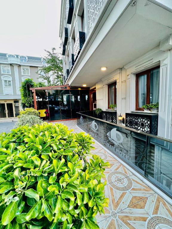 a balcony of a building with a large green bush at Liman Hotel in Istanbul