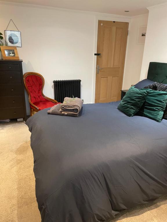 a bedroom with a bed and a red chair at Grade II boho home in the heart of Oxford St. in Southampton