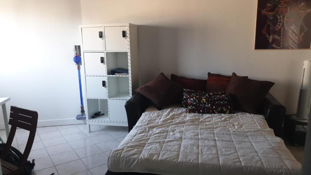 a bedroom with a bed and a white cabinet at T2 à 9 mins du château 4pers in Le Chesnay