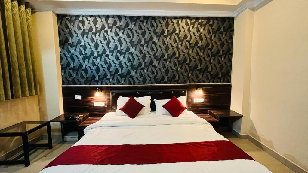 a bedroom with a large bed with red pillows at CORAL TREE INN in Lucknow