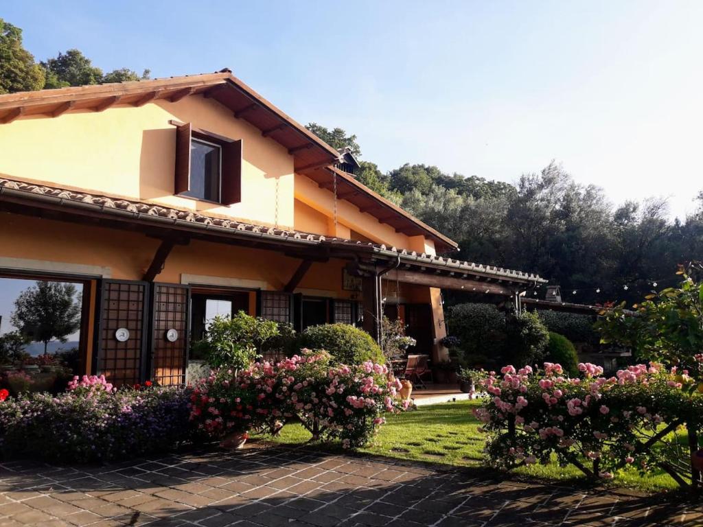 une maison avec des fleurs devant elle dans l'établissement La Cerasa - Country house il lago fuori, à Bracciano