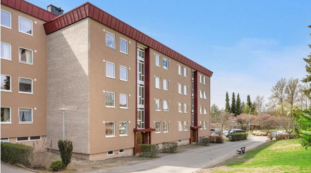 a large brick building on the side of a street at Privat room in shared 3 rooms apartment Manglerud in Oslo