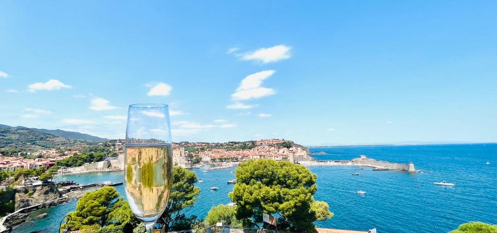 a glass of champagne sitting on top of a city at Vue exceptionnelle sur la baie de Collioure in Collioure