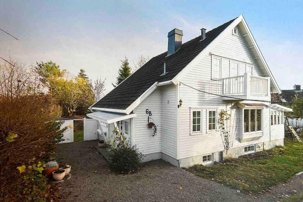 ein weißes Haus mit Balkon darüber in der Unterkunft Basement apartment in Sandefjord
