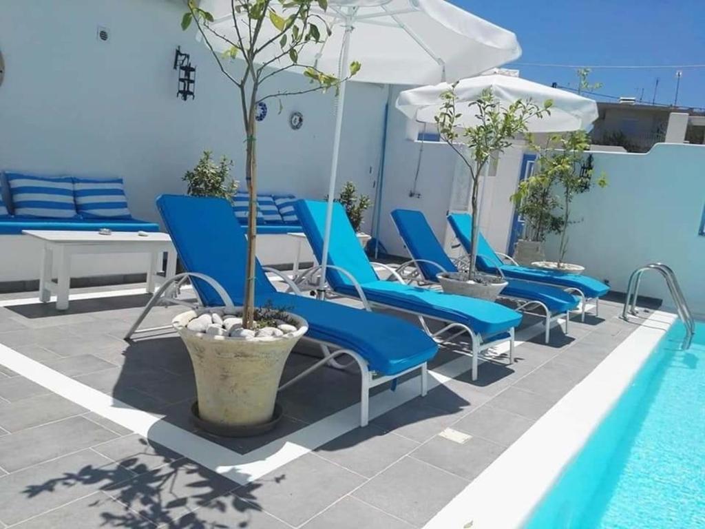 a row of blue chairs next to a swimming pool at Jasmine Suites Poolhouse Rhodos in Koskinou