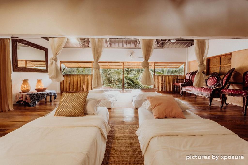 a living room with two white beds in it at Tirtha Quddus Farmstay in Bentong