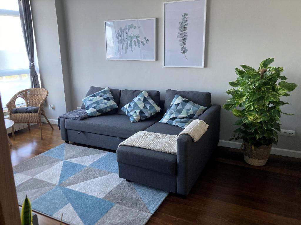 a living room with a blue couch and a rug at Apartamento El Espigón (Cimadevilla) in Gijón