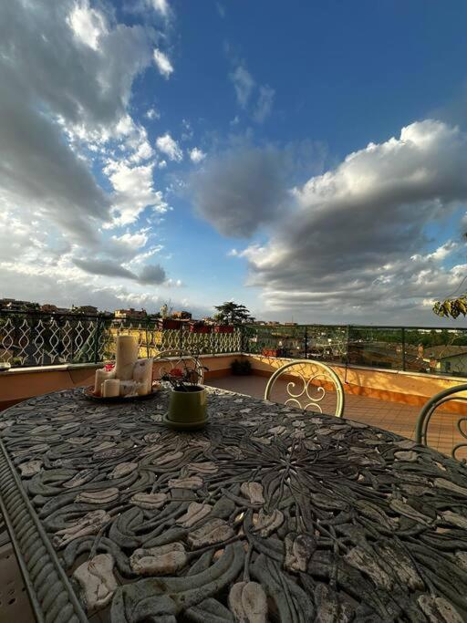 eine Terrasse mit einem Tisch und Stühlen auf dem Balkon in der Unterkunft Penthouse Ryder Cup in Rom