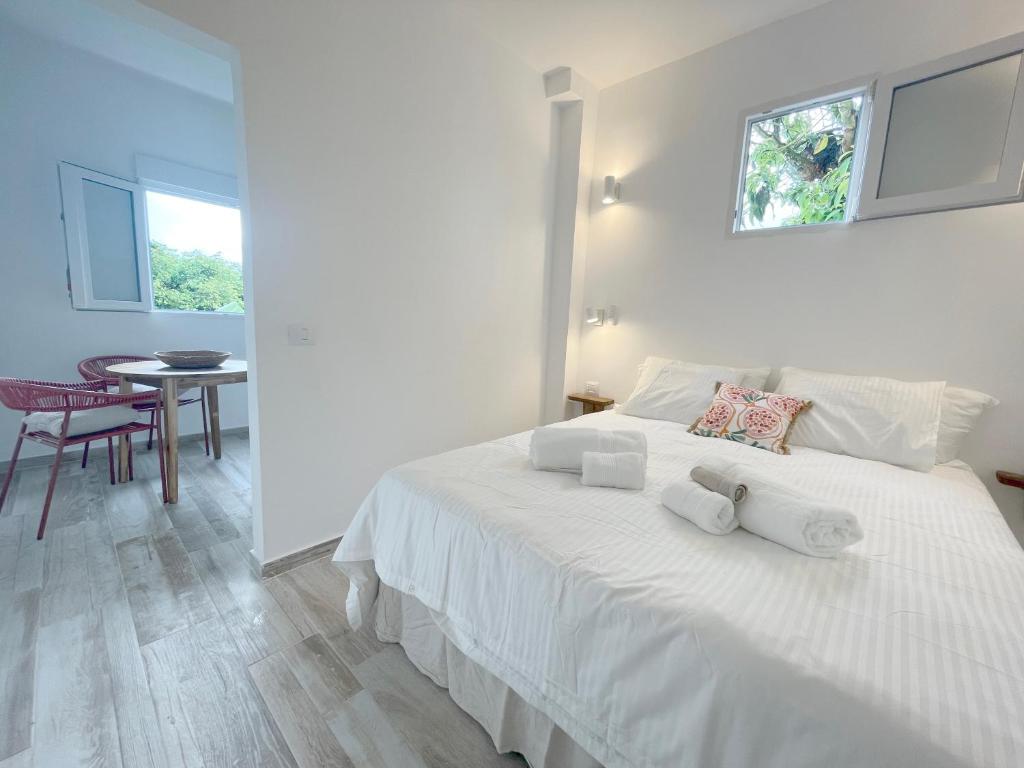 Un dormitorio con una cama blanca con toallas. en Eden Gomera Suites en Agulo