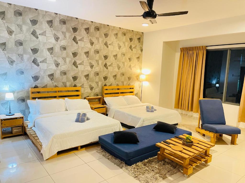 - une chambre avec 2 lits, 2 chaises et un ventilateur de plafond dans l'établissement Subang Jaya/ Da Men, Cozy Homestay/ Sunway, à Subang Jaya