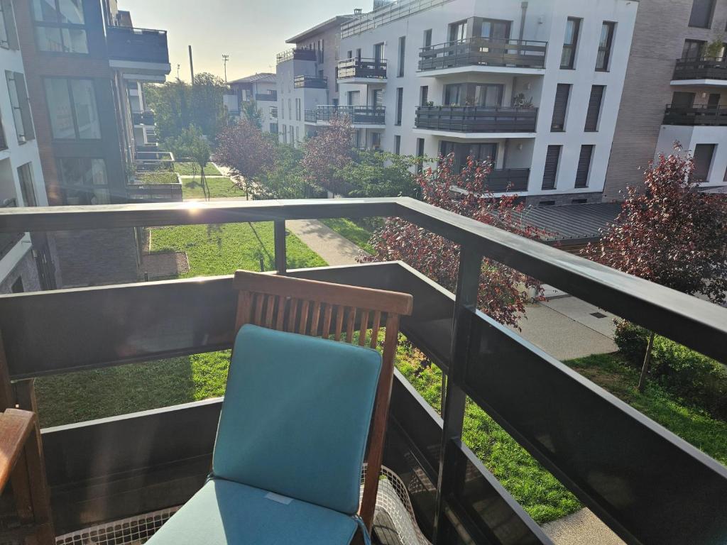 a blue chair sitting on the balcony of a building at Appartement avec Balcon Pontoise PARIS Nord-ouest in Pontoise