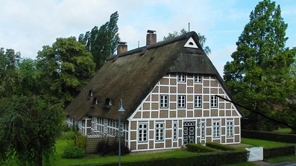 a large white and brown house with a roof at Haus am Fluß in Oberndorf