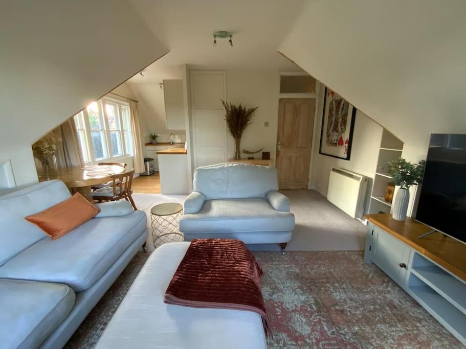 a living room with a couch and a tv at Ipsley Lodge Apartment Surrey Hills in Farnham