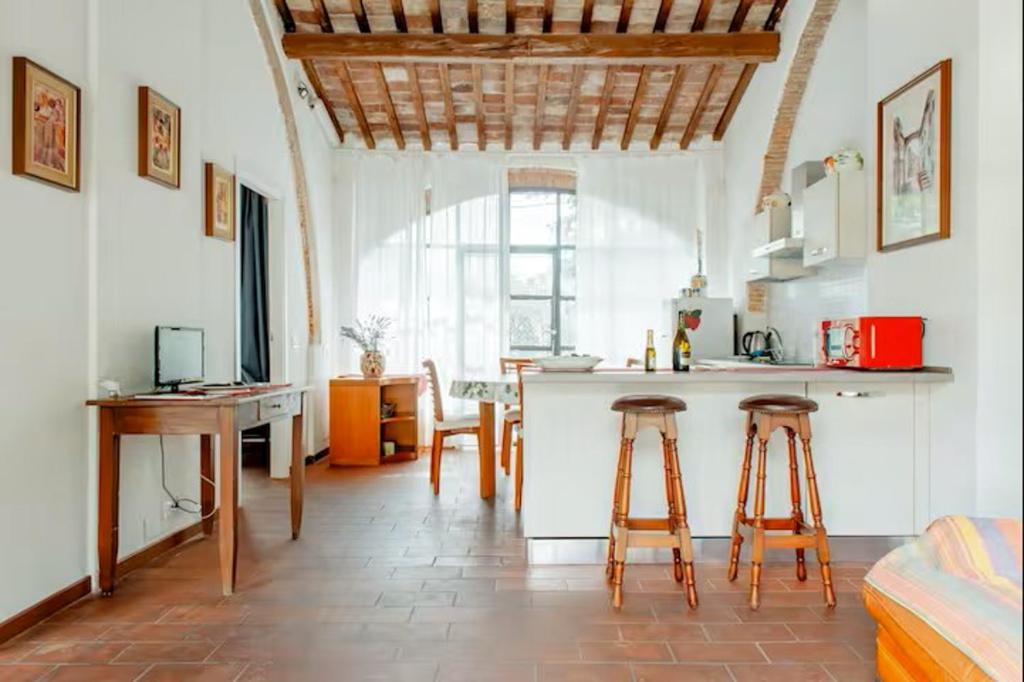 a kitchen and living room with a counter and stools at Casavacanzepisa in San Giuliano Terme