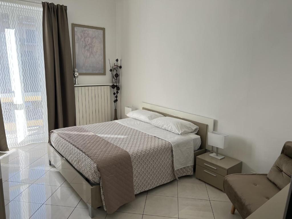 a bedroom with a bed and a chair and a window at Lingotto35 in Turin