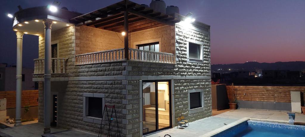 Cette maison en briques dispose d'un balcon et d'une piscine. dans l'établissement Mahdi villa مهدي فيلا, à Jéricho