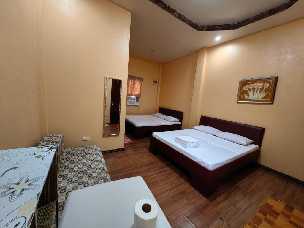 um quarto de hotel com duas camas e uma mesa em Lagnason's Place em Oslob