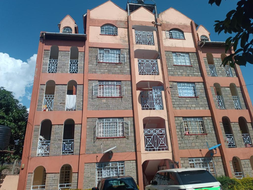 un edificio de ladrillo alto con muchas ventanas en Merc apartment, en Kisumu