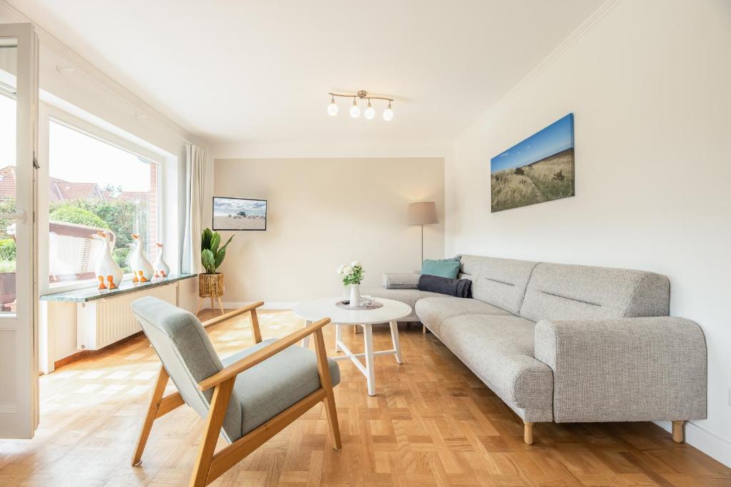 uma sala de estar com um sofá e uma mesa em Appartement Olivia em Westerland