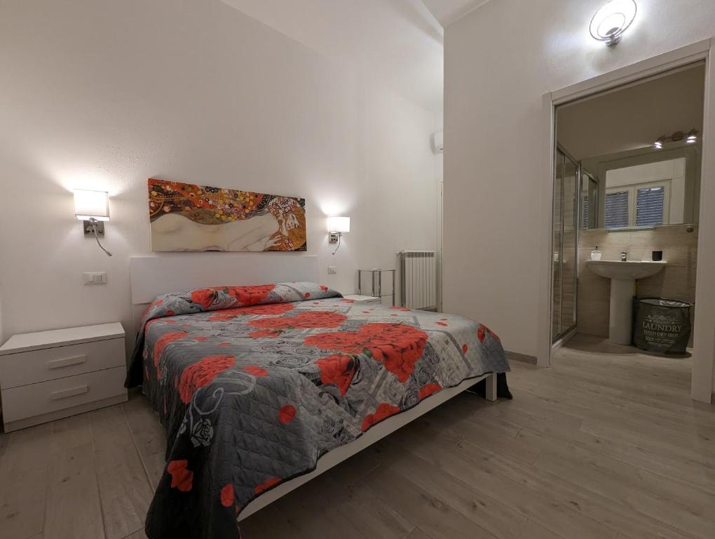 um quarto com uma cama e uma casa de banho com um lavatório em Il Centro em Camaiore