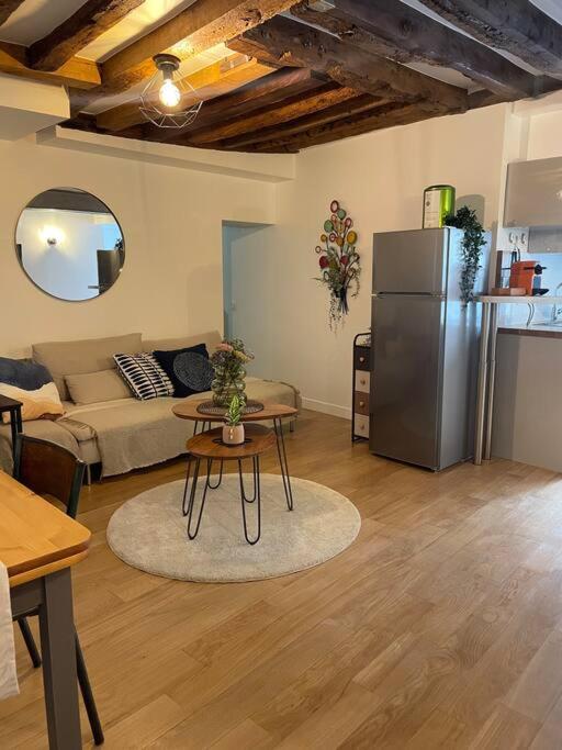- un salon avec un réfrigérateur et une table dans l'établissement Lovely apartment Central, Le Marais, Paris, à Paris