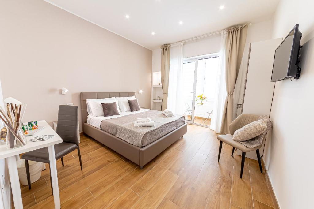 um quarto com uma cama, uma escrivaninha e uma TV em White Gold em Nápoles