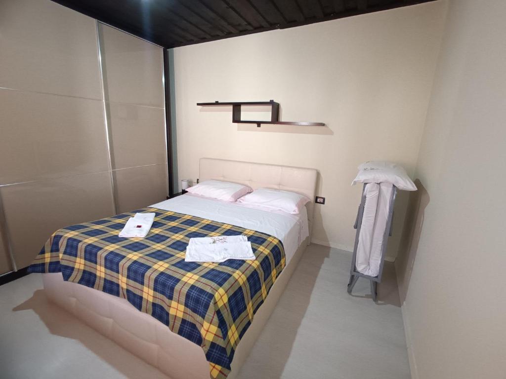 a small bedroom with a bed with a plaid blanket at Sermi's House in Shkodër