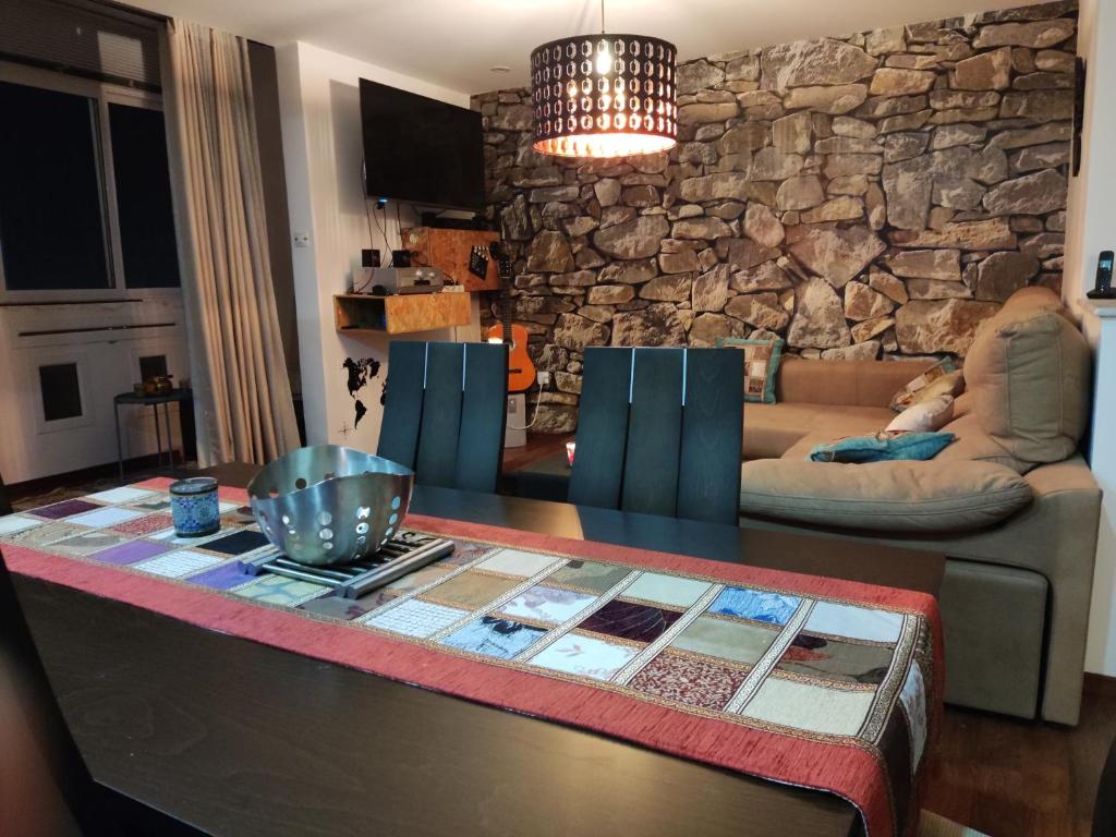 ein Wohnzimmer mit einem Tisch und einer Steinmauer in der Unterkunft Appartement Haut standing F3 Alger , El Alchour in Alger