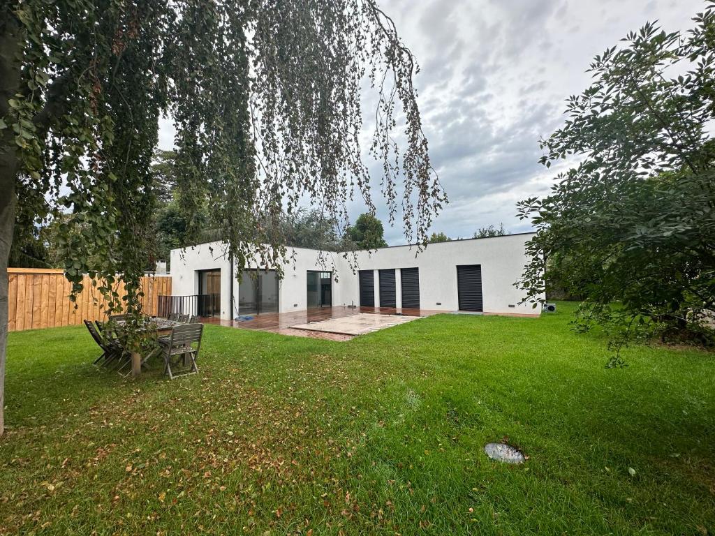 a white building with a picnic table in a yard at Maison Villa à proximité du zoo de Thoiry in Arnouville-lès-Mantes