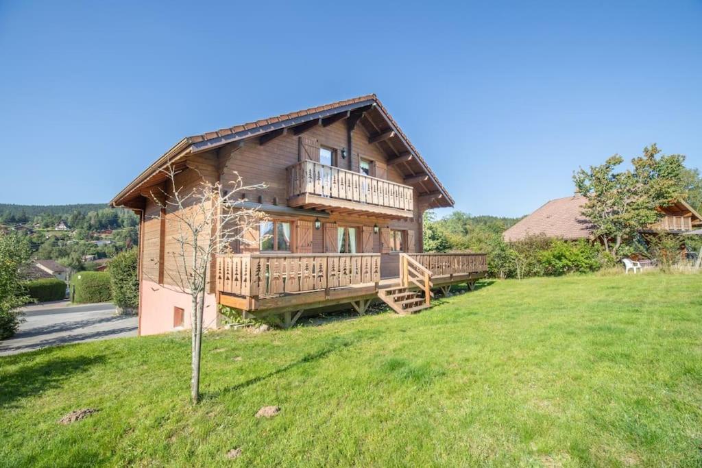 duży drewniany dom na wzgórzu z ogródkiem w obiekcie Les Griottes, véritable chalet de montagne, avec Jacuzzi et Sauna w mieście Xonrupt-Longemer