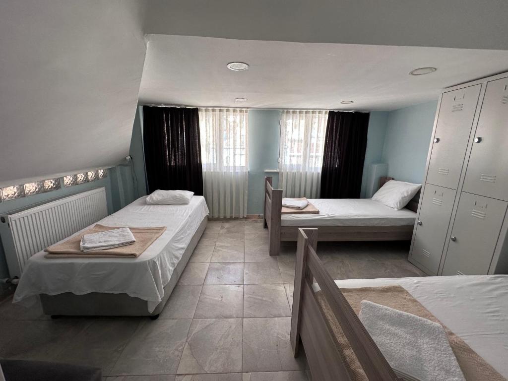 Habitación pequeña con 2 camas y mesa. en STONE HOME Hostel, en Estambul