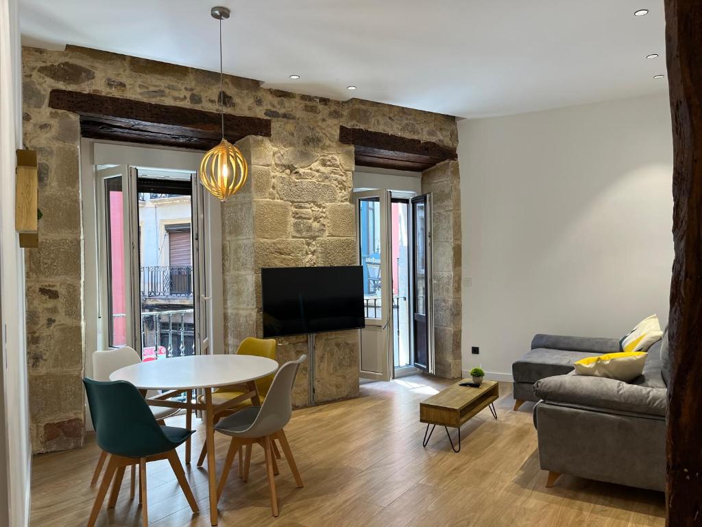 een woonkamer met een tafel en een bank bij Apartamento en el Casco Viejo in Bilbao