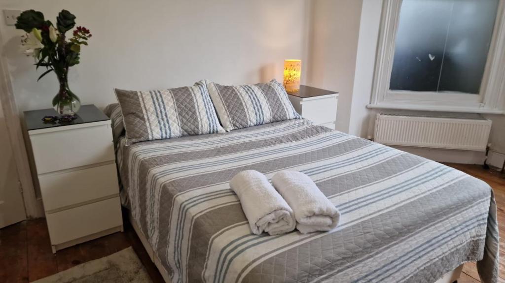 ein Schlafzimmer mit einem Bett mit Handtüchern darauf in der Unterkunft Peaceful well equipped flat near central London in London